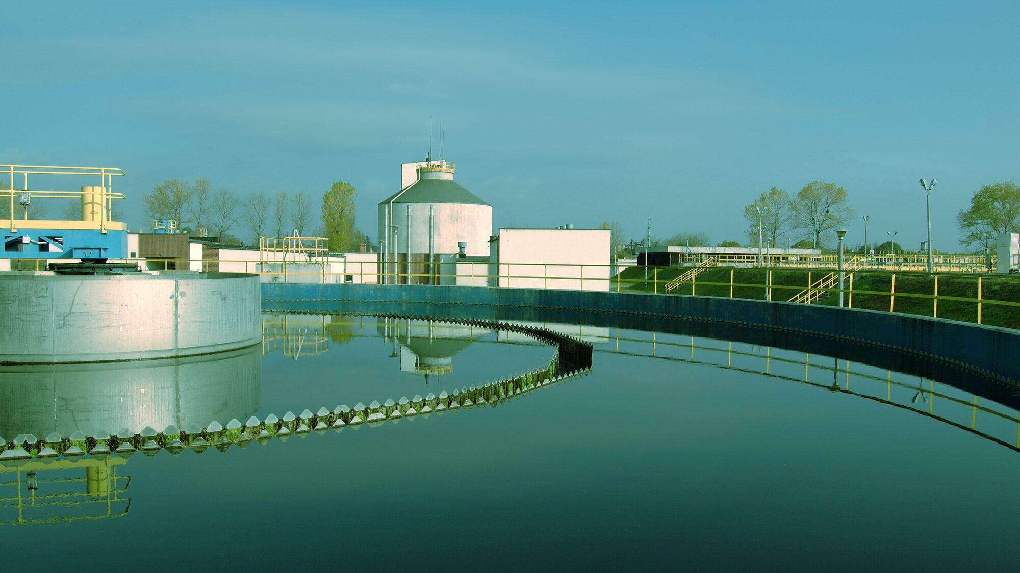 Treatment plant tanks and buildings under a clear sky
