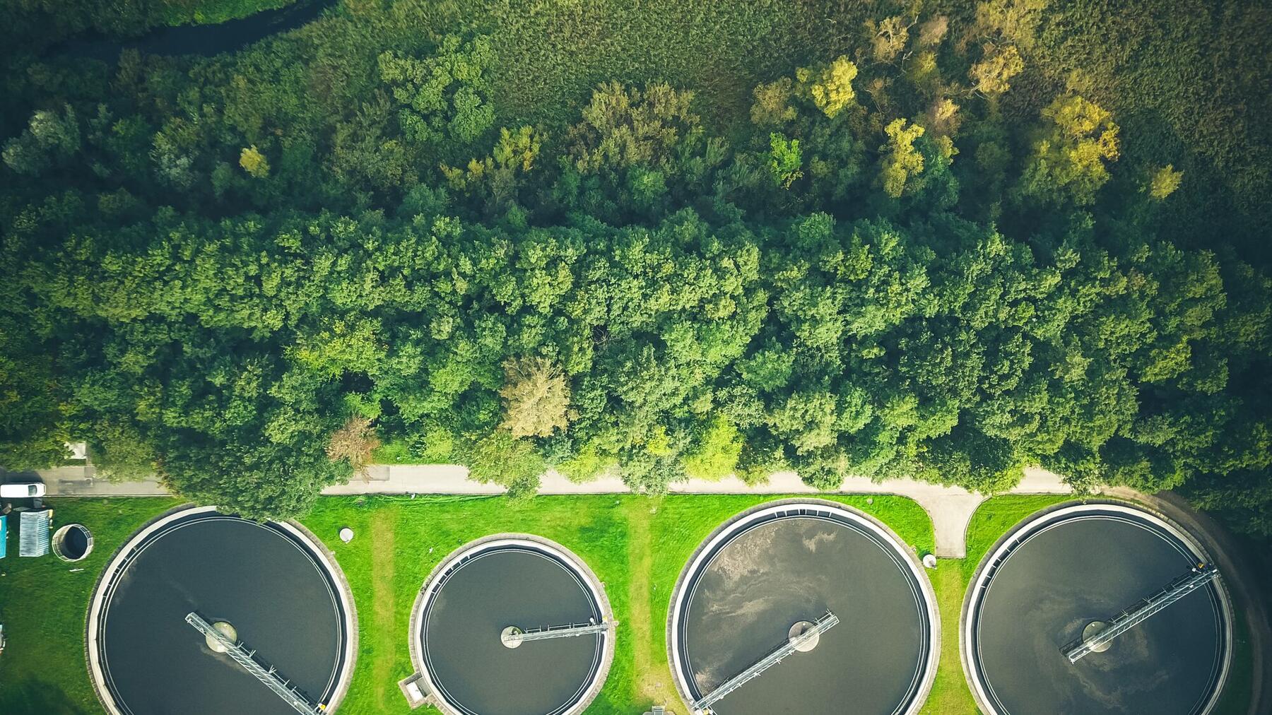Aerial view of treatment tanks beside woodland